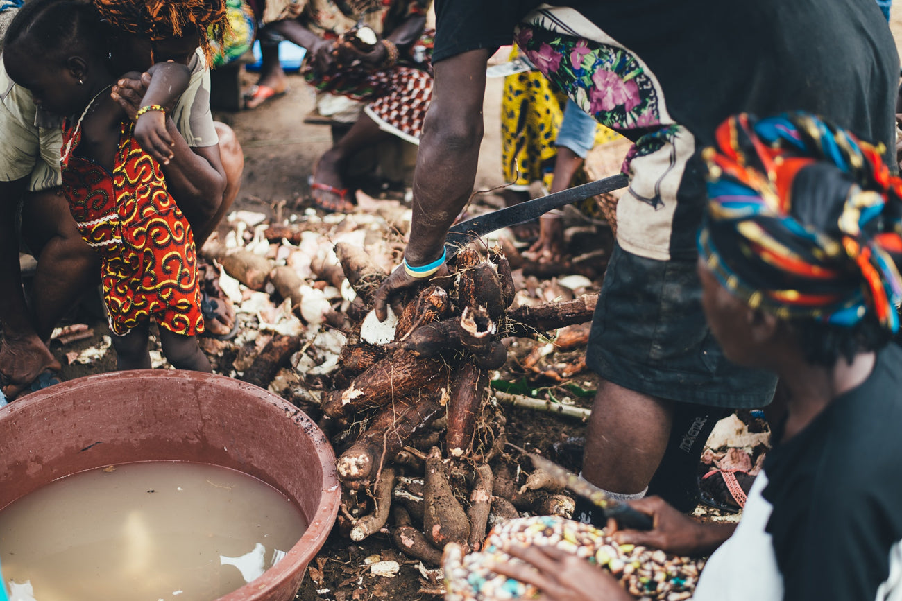 Mujeres africanas cocinando junto a un niño 