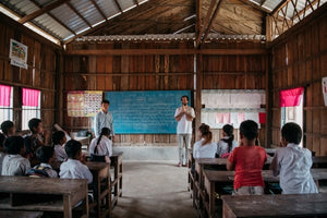 Interior de una escuela en Camboya con niños dando clase y Pablo Urbano fundador de AUARA presentandose