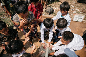 Niños jugando en un pozo de agua en camboya, beneficiarios de un proyecto de AUARA y AVEDA