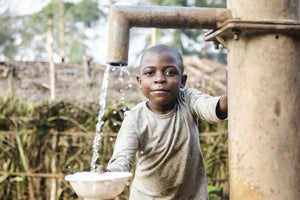 Niño beneficiario de un proyecto de Camerún recogiendo agua del pozo 