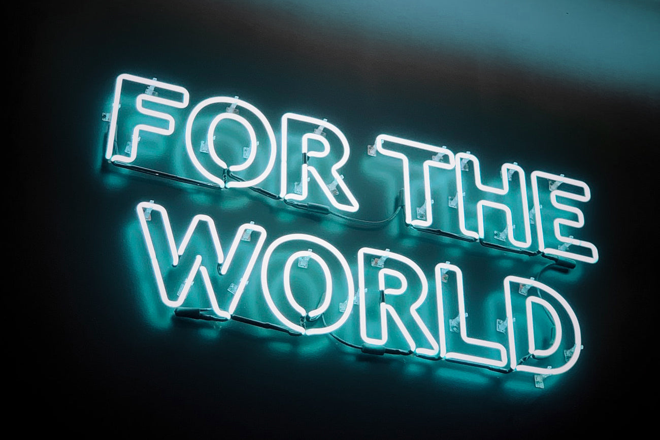 Letrero de luces de neón en el que se puede leer "For the world"