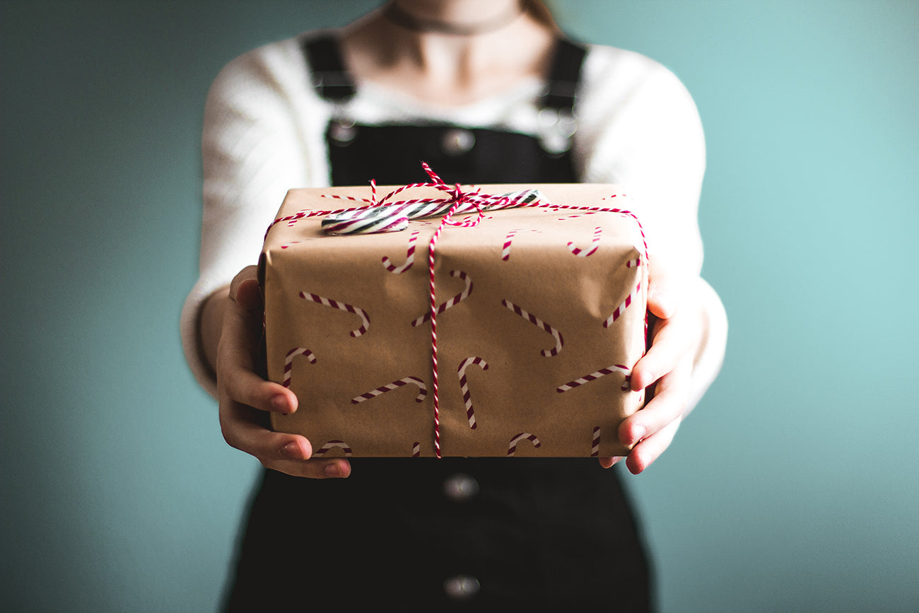 Chica entregando un regalo de navidad