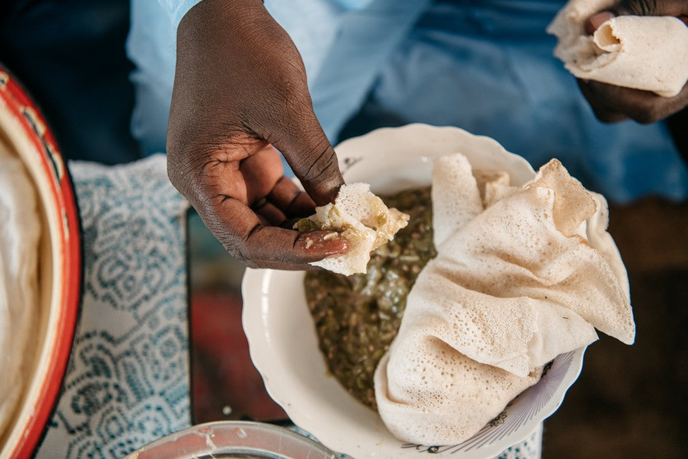 Mano de mujer del chad ofreciendo comida típica