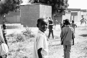 Foto en Blanco y Negro de varios niños de espaldas y el Chad y uno mirando a cámara. Proyecto de AUARA