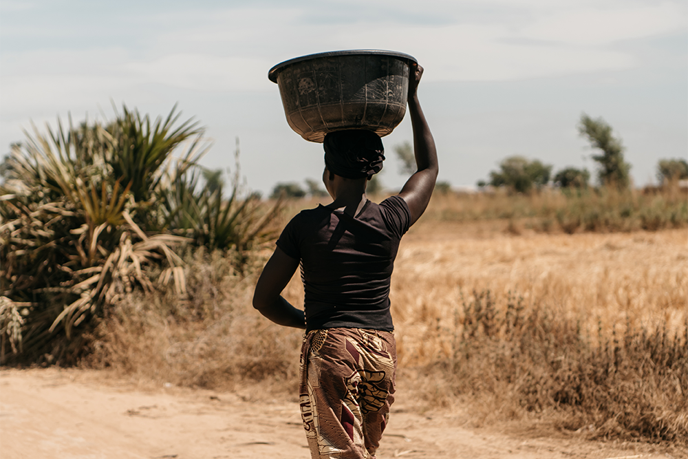 Mujer llevando una cesta en la cabeza