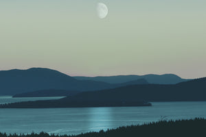 Imagen de un paisaje natural de un lago, montañas y la luna en el cielo